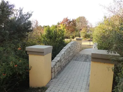 a stone fence and a walkway in a park at Strawberry Fields Country Manor Guest House in Johannesburg