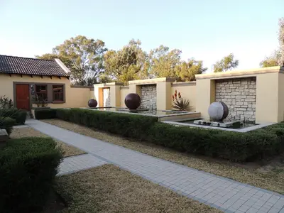 a house with hedges in front of a walkway at Strawberry Fields Country Manor Guest House in Johannesburg
