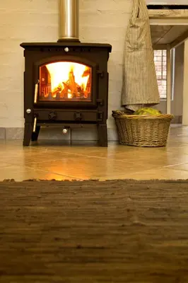 a fireplace in a living room with a fire in it at Pumpkin Tree Guesthouse in Middelburg