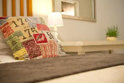 a pillow on a bed with a table and a mirror at Pumpkin Tree Guesthouse in Middelburg