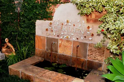 a water feature in a garden with a fountain at Pumpkin Tree Guesthouse in Middelburg