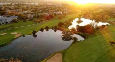 an aerial view of a golf course with a pond at The Woodpecker Inn in Pretoria