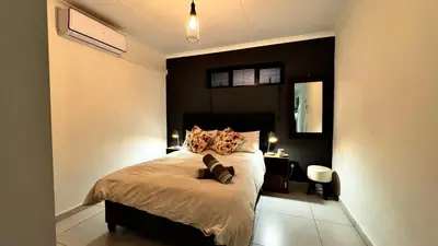 a bedroom with a bed with a black wall at Micro Urban Oasis 2 in Pretoria