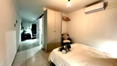a bedroom with a bed and a chair in it at Micro Urban Oasis 2 in Pretoria