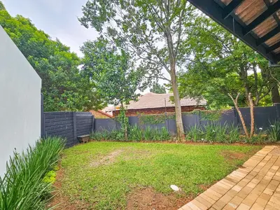 a backyard with a fence and a yard withgrass at Micro Urban Oasis 2 in Pretoria