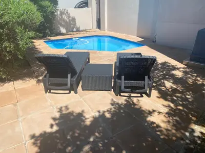 an overhead view of two chairs and a swimming pool at Golf Suites @ Copperleaf in Centurion