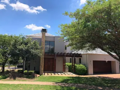 a white house with a chimney and a garage at Golf Suites @ Copperleaf in Centurion