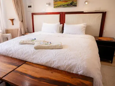 a bedroom with a large bed with towels on it at Sleepers Villa Guesthouse in Polokwane