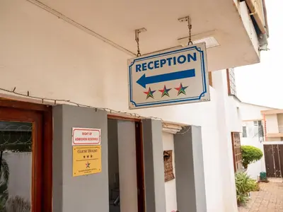 a sign for reception on the side of a building at Sleepers Villa Guesthouse in Polokwane