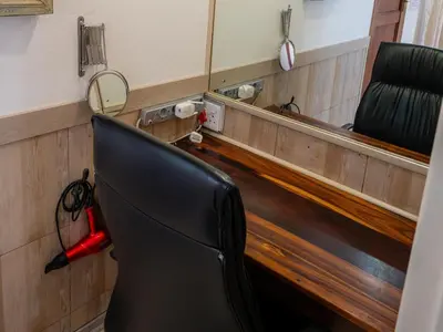 a black chair sitting in front of a mirror at Sleepers Villa Guesthouse in Polokwane
