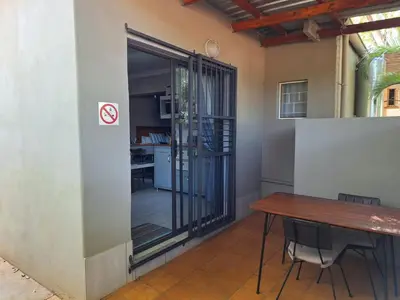 a dining room with a table and a sliding glass door at 1@Kruger in Mokopane