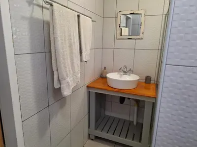 a white bathroom with a sink and a mirror at 1@Kruger in Mokopane