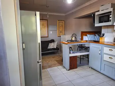 a kitchen with blue cabinets and a couch in a room at 1@Kruger in Mokopane