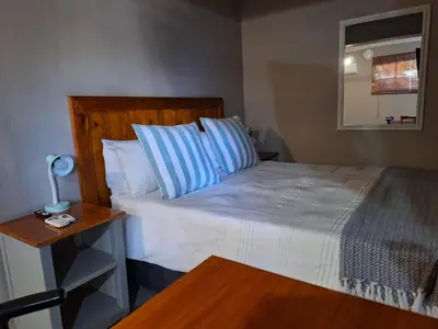a bedroom with a bed with blue and white pillows at 1@Kruger in Mokopane