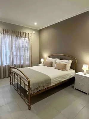a bedroom with a large bed and a window at Angel’s Nest Nelspruit in Nelspruit