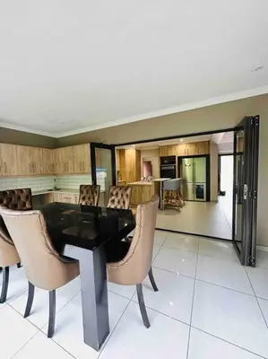 a dining room with a table and chairs and a kitchen at Angel’s Nest Nelspruit in Nelspruit