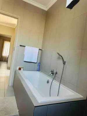 a bathroom with a tub with a towel on the wall at Angel’s Nest Nelspruit in Nelspruit