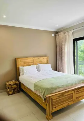 a bedroom with a large wooden bed and a window at Angel’s Nest Nelspruit in Nelspruit