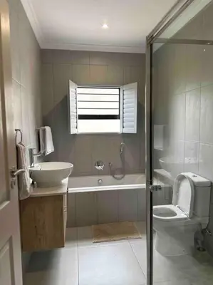 a bathroom with a sink and a toilet and a shower at Angel’s Nest Nelspruit in Nelspruit
