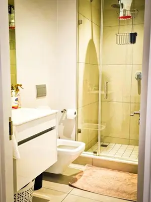 a bathroom with a shower and a toilet and a sink at Luxurious, affordable Ellipse apartment in Midrand