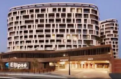 a tall white building with a bus in front of it at Luxurious, affordable Ellipse apartment in Midrand