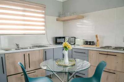 a kitchen with a glass table with a vase of flowers at Masana at Homely Escape in Phalaborwa