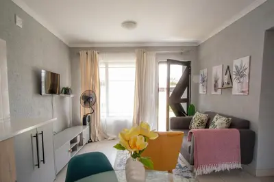 a living room with a couch and a window at Masana at Homely Escape in Phalaborwa
