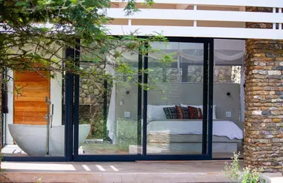 a glass room with a bed inside of it at Ungava Retreat in Marloth Park