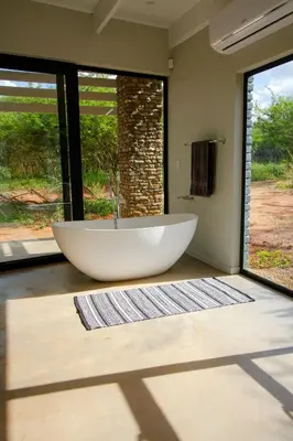 a large tub in a bathroom with a large window at Ungava Retreat in Marloth Park