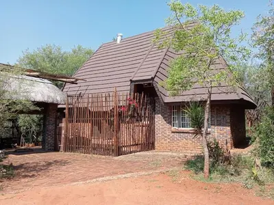 a brick house with a gate in front of it at Hedgehog Cabin in Marloth Park