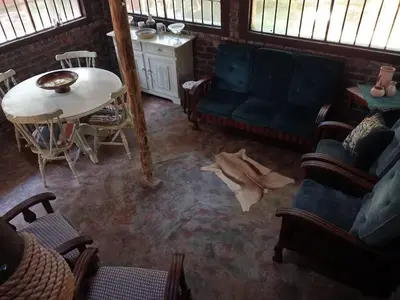 a living room with a couch and a table at Hedgehog Cabin in Marloth Park