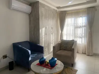 a living room with a chair and a table at Hotel El Infinito in Kempton Park
