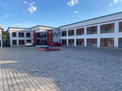 a large white building with a car parked in it at Hotel El Infinito in Kempton Park