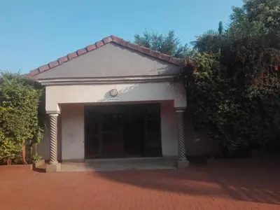 a building with a large garage on a brick driveway at DZUVHA VILLAGE INN in Thohoyandou