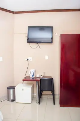 a room with a table and a tv on the wall at DZUVHA VILLAGE INN in Thohoyandou