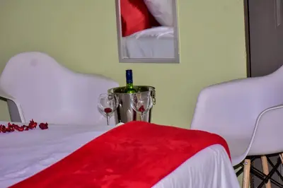 a table with two glasses and a bottle of wine at Mashaka Ashu Lodge in Dzindi