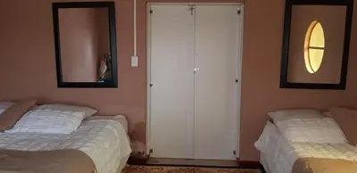 a bedroom with two beds and a closet and a mirror at Molata Rabs in Polokwane