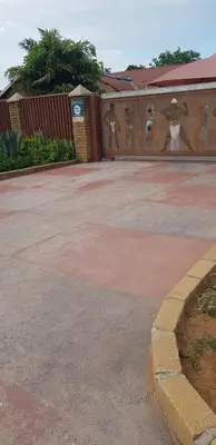 a parking lot with a wall with paintings on it at Molata Rabs in Polokwane