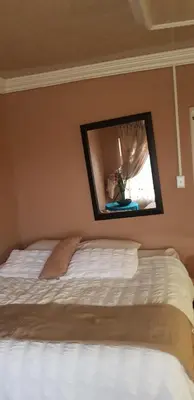 a bedroom with a bed with a mirror on the wall at Molata Rabs in Polokwane