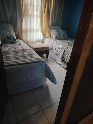 a bedroom with two beds and a window at Molata Rabs in Polokwane