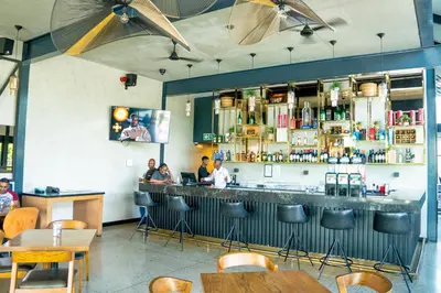 a restaurant with people sitting at a bar at Secure 1 Bedroom Apartment in Midrand, Waterfall City - Lock Up and Go - Free WIFI and Parking - 9 Elizabeth Place in Midrand