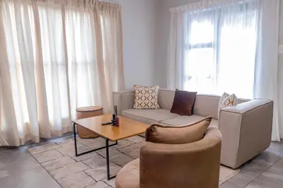 a living room with a couch and a table at Secure 1 Bedroom Apartment in Midrand, Waterfall City - Lock Up and Go - Free WIFI and Parking - 8 Elizabeth Place in Midrand