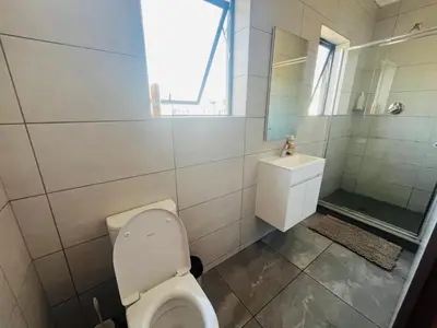 a bathroom with a toilet and a sink at 4 Elizabeth Place - Beautiful 1 bedroom unit next to Kyalami Racetrack with free WiFi swimming pool gym and restaurant - Perfect for a Couple in Midrand Waterfall in Midrand