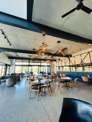 a dining room with tables and chairs and windows at 4 Elizabeth Place - Beautiful 1 bedroom unit next to Kyalami Racetrack with free WiFi swimming pool gym and restaurant - Perfect for a Couple in Midrand Waterfall in Midrand