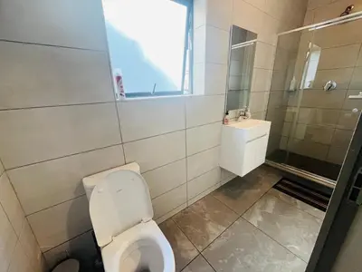 a bathroom with a toilet and a sink at 4 Elizabeth Place - Beautiful 1 bedroom unit next to Kyalami Racetrack with free WiFi swimming pool gym and restaurant - Perfect for a Couple in Midrand Waterfall in Midrand