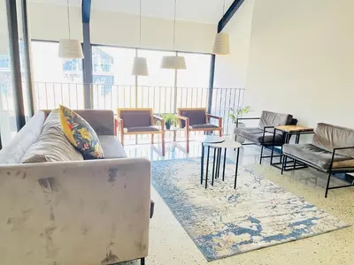 a living room with a couch and chairs and a table at 10 Elizabeth Place - Beautiful self catering 2 bedroom unit next to Kyalami Racetrack with free WiFi swimming pool gym and restaurant - Perfect for a small family in Midrand Waterfall in Midrand