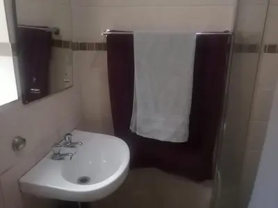 a bathroom with a sink and a white towel at GLORIA'S GUESTS.COM in Polokwane