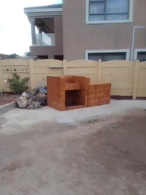 a brick fire pit in front of a fence at GLORIA'S GUESTS.COM in Polokwane