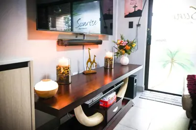 a room with a table with candles and a tv at Air-Conditioned, Self-Catering Apartment with Heated Pool Near OR Tambo International Airport in Benoni