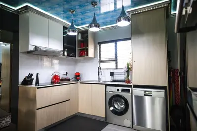 a kitchen with a washing machine and a washer at Air-Conditioned, Self-Catering Apartment with Heated Pool Near OR Tambo International Airport in Benoni